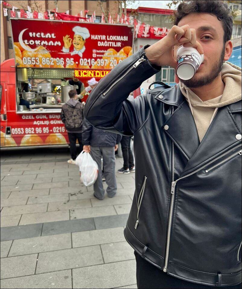 Bardakta sıcak hayır çorbası içen genç