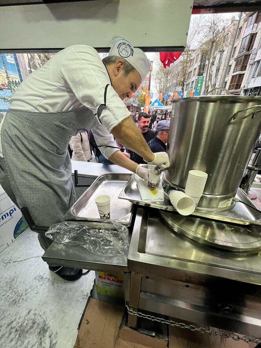 Hijyen kurallarına uygun kıyafet ve eldivenle hayır çorbası servisi yapan aşçı